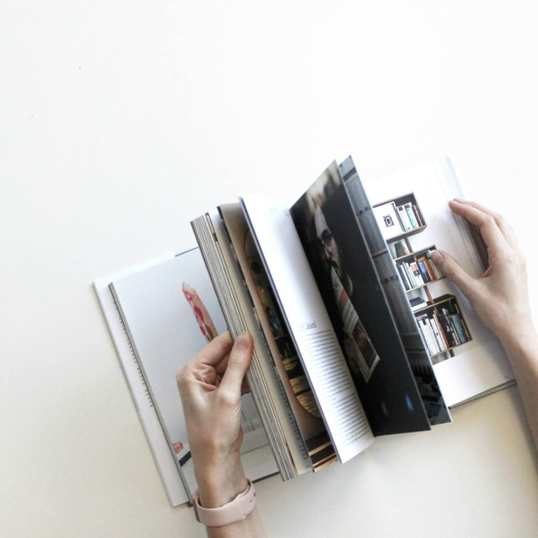 Hands turning the pages of a printed photo book