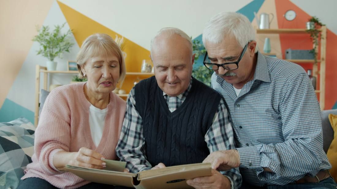 Grandparents looking at photos with a grandchild